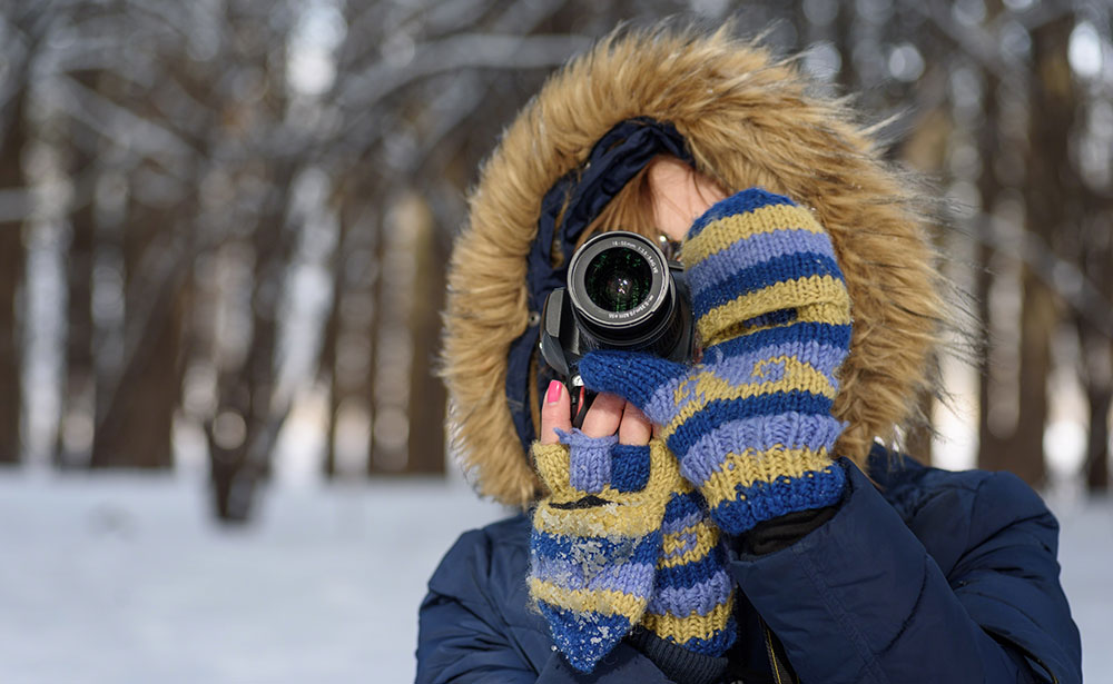 vrouw fotografeert in winterse omgeving